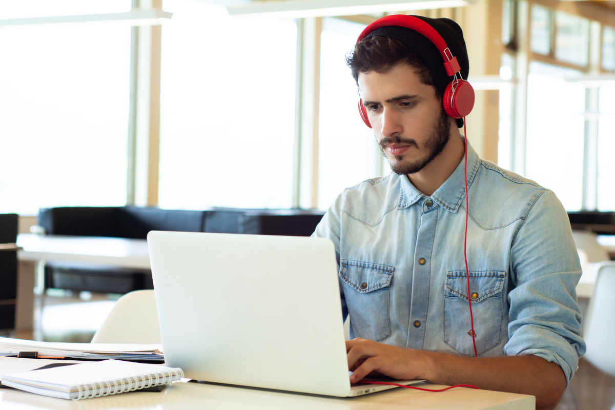 a man wearing headphones working on his laptop